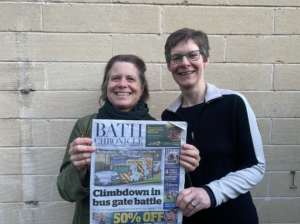 Green Party Cllrs Joanna Wright and Saskia Heijltjes holding a copy of the Bath Chronicle, featuring the cancelled bus gate as the cover story